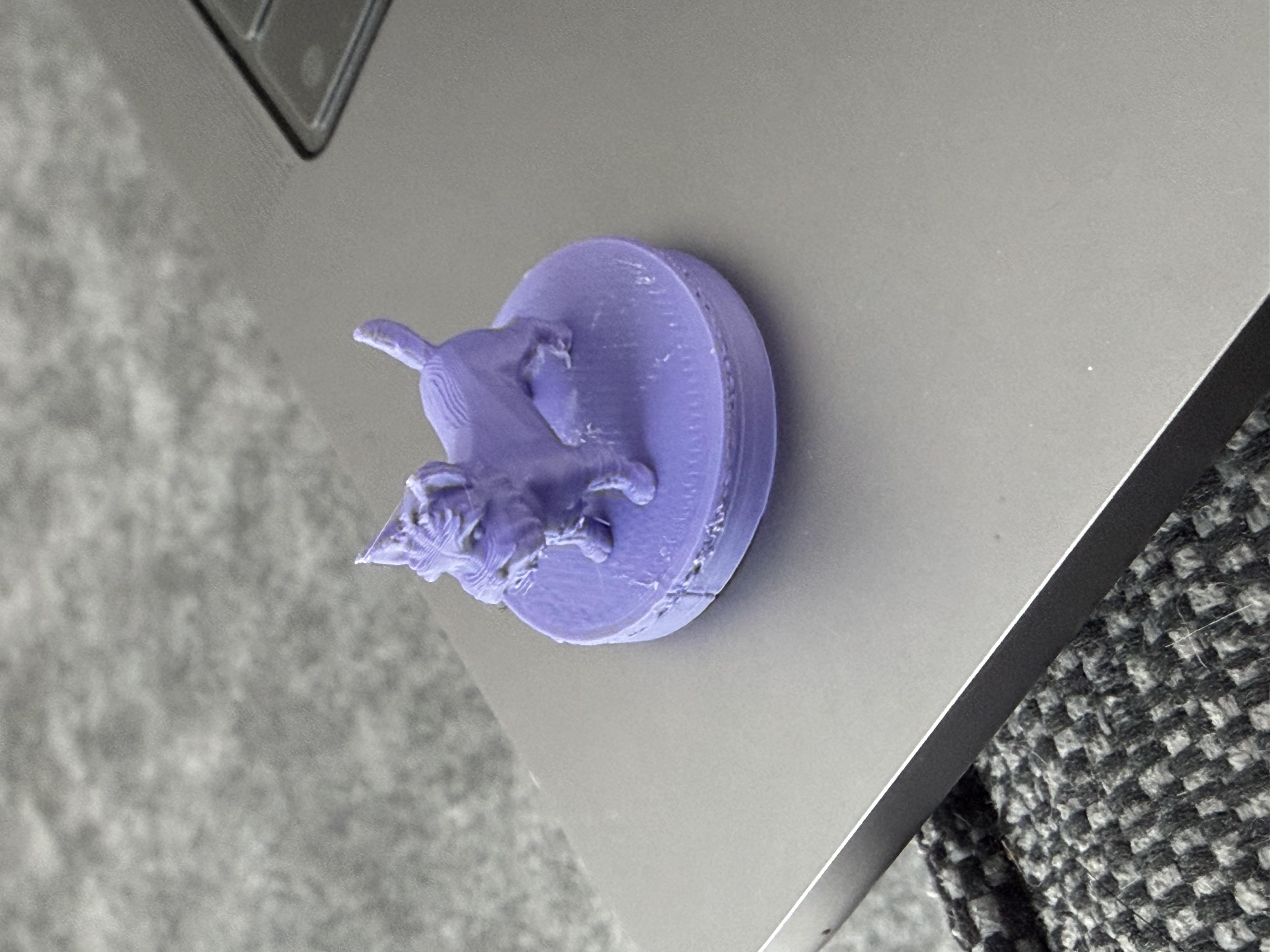 A 3D-printed disc tag with a small figurine modelled on top, the figurine-variant of the NFC tag enclosure